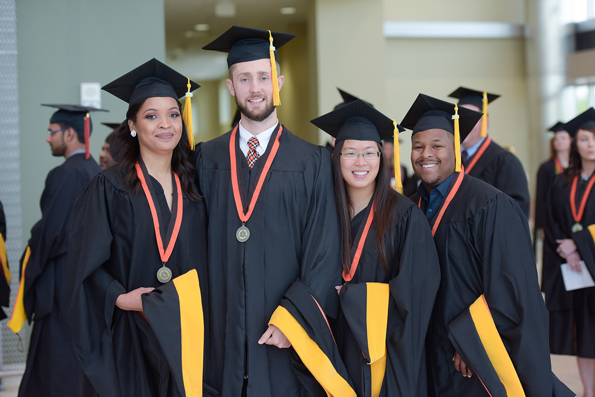Four students in graduation robes