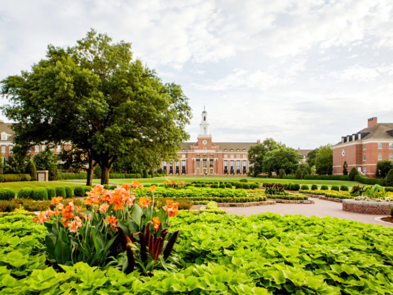 An exterior photo of the Edmon Low Library with flowers in the foreground.